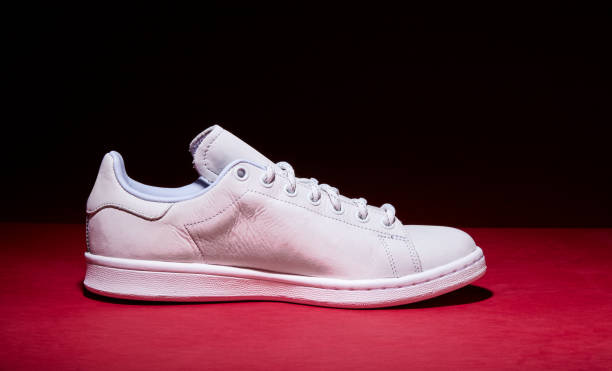 istock White Tennis Shoe - Red Background 939840322