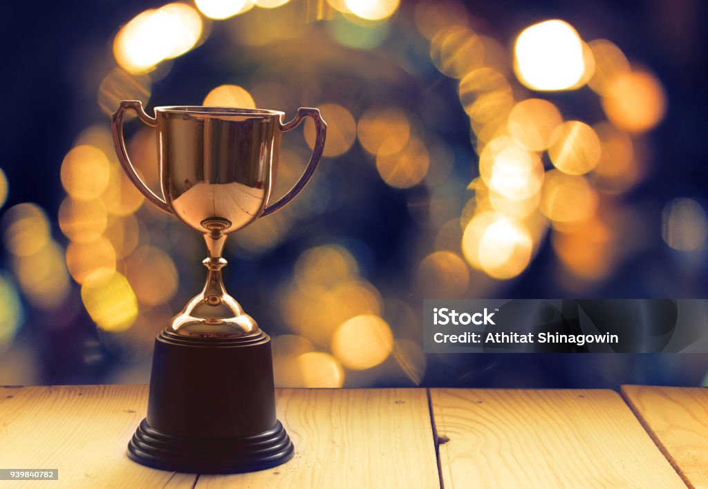 Ganar Premio Trofeo en mesa de madera con ventana en segundo plano. - Foto de stock de Premio libre de derechos