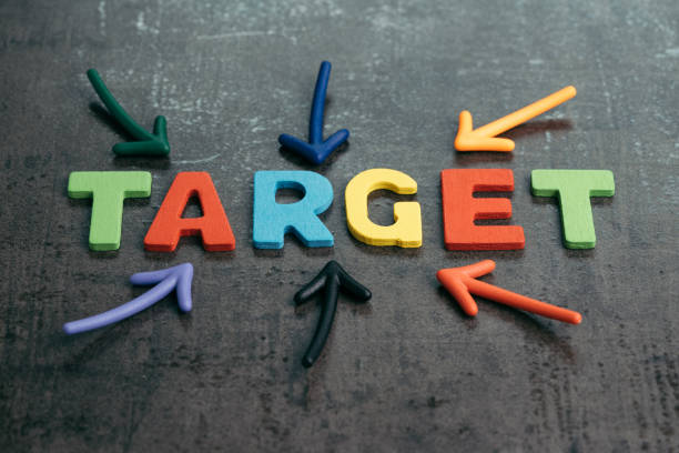 istock Business target plan or goal for success concept, multi colorful magnet arrows pointing at wooden letters the word TARGET at the center on chalkboard loft cement wall 939841548