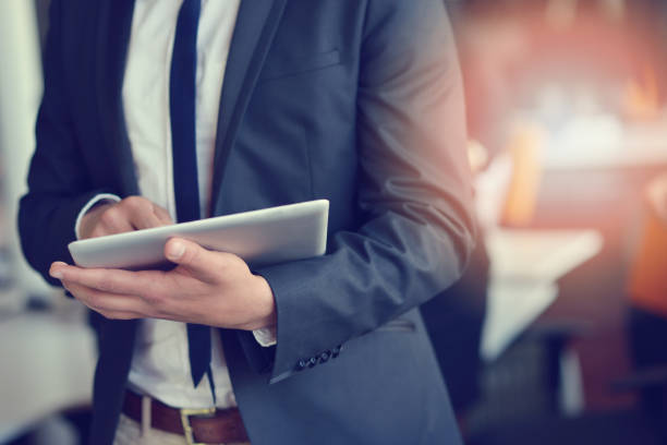 istock Midsection of businessman using digital tablet in office 939842260