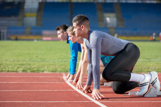 atleti alla linea di partenza sprint in pista e in campo - rivalry starting block track and field athlete track and field foto e immagini stock