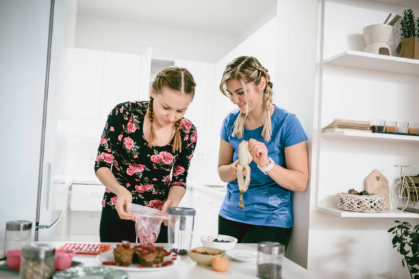 istock Two Adorable Females Making Smoothie with Fresh Ingredients 939844962