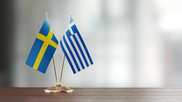 istock Swedish And Greek Flag Pair On A Desk Over Defocused Background 939845004