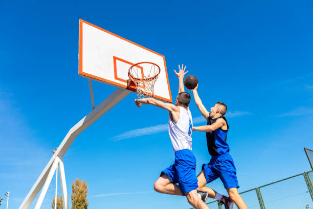 istock Young Basketball street player making slam dunk 939845350