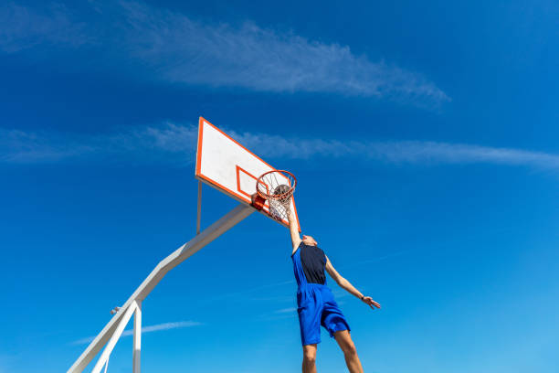 istock Young Basketball street player making slam dunk 939845438