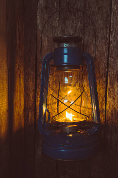 istock Kerosene lamp illuminates the old wooden wall 939845568