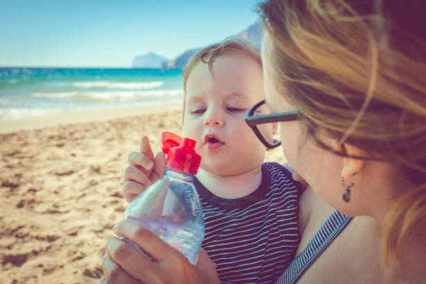 istock Child drinking water on the beach 939848370