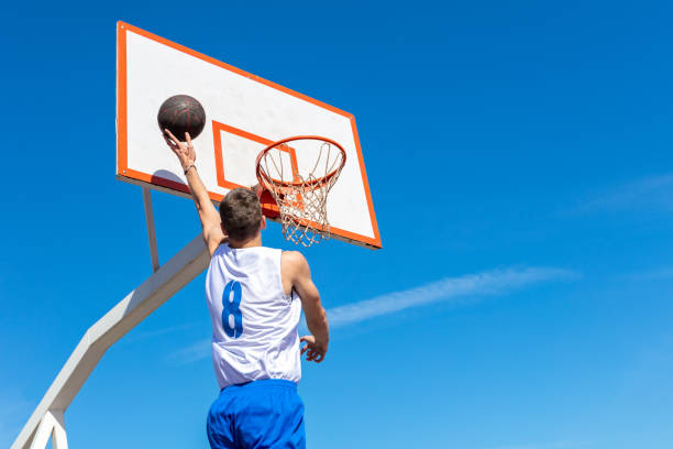 istock Young Basketball street player making slam dunk 939848746
