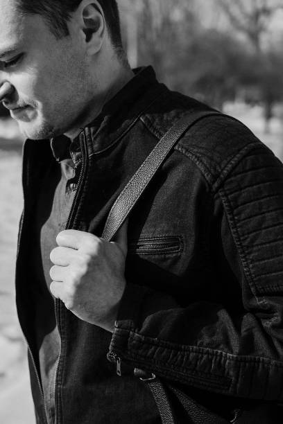 istock Young man in black denim jacket and leather backpack walking. Selective focus. 939848820