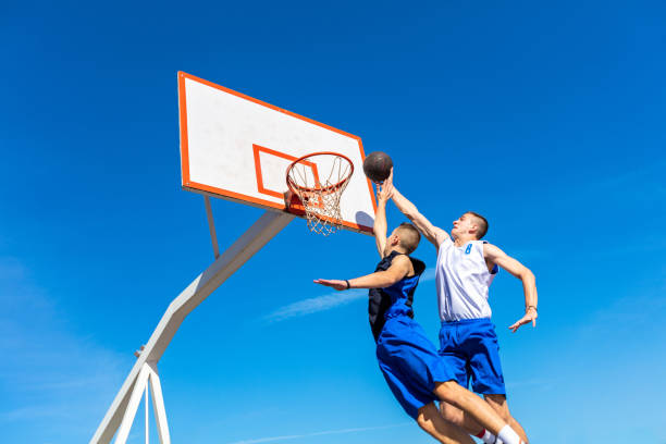 istock Young Basketball street player making slam dunk 939851722