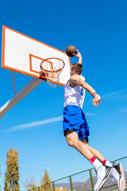 istock Young Basketball street player making slam dunk 939852872