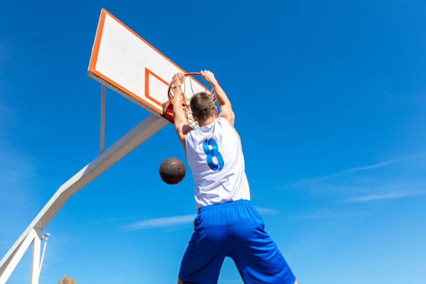 istock Young Basketball street player making slam dunk 939855082