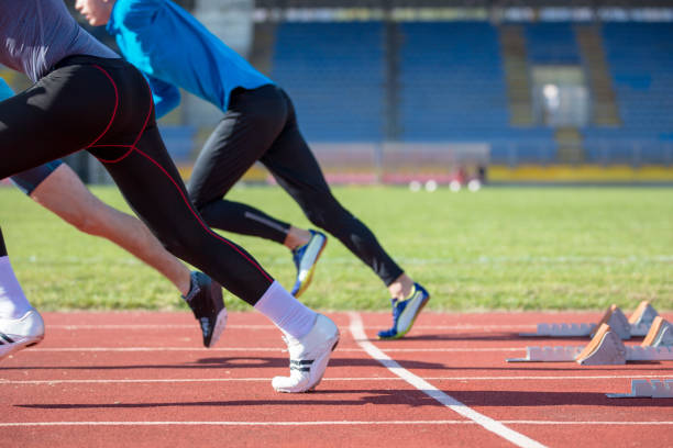 athletes at the sprint start line in track and field - starting line sprinting track and field track event imagens e fotografias de stock