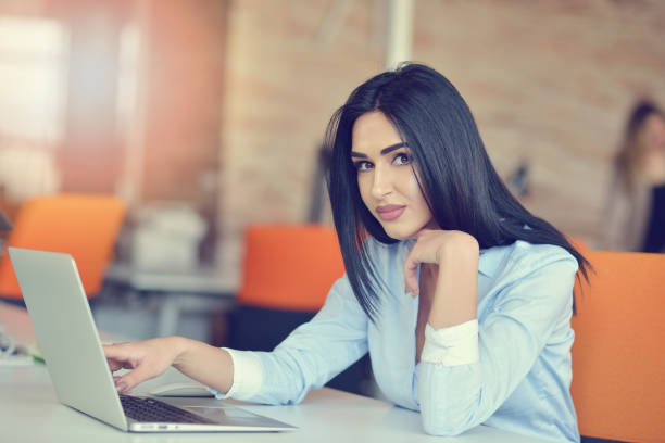 istock Image of woman using laptop while sitting at her desk. 939855456