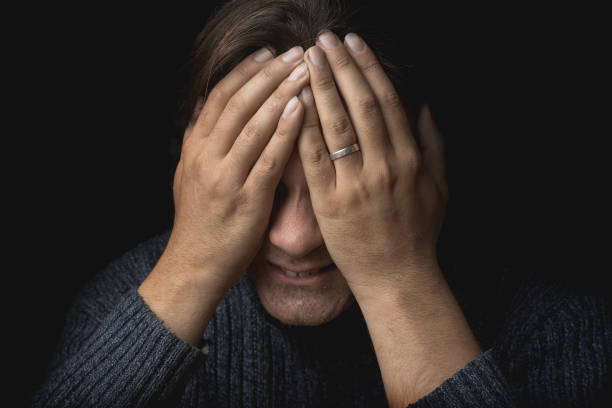 istock Crying man suffers and covers his face with hands. Depression, mental pain, tragedy, problems in life and grief concept 939856116