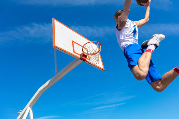 istock Young Basketball street player making slam dunk 939859276