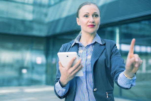 istock Employee woman with tablet touching finger on air 939865494