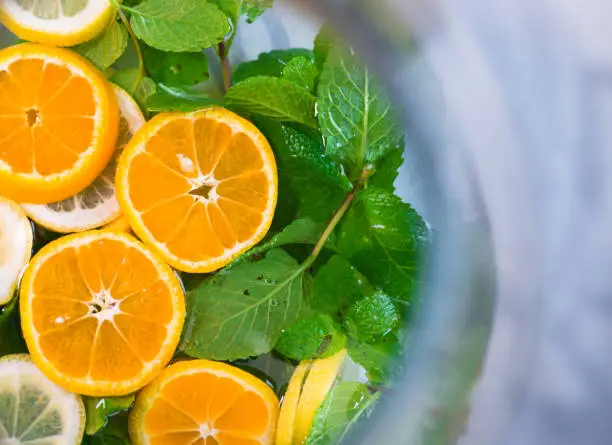 Photo of Delicious refreshing drink with mint leaves and sliced lemon in a glass decanter