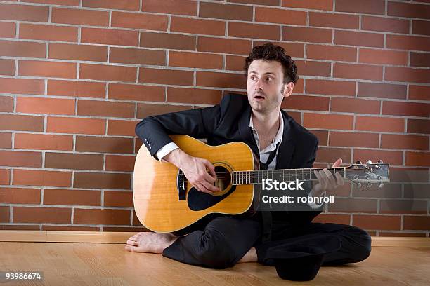 Geschäftsmann Sitzt Mit Einer Gitarre Auf Dem Boden Und Singt Stockfoto und mehr Bilder von Armut