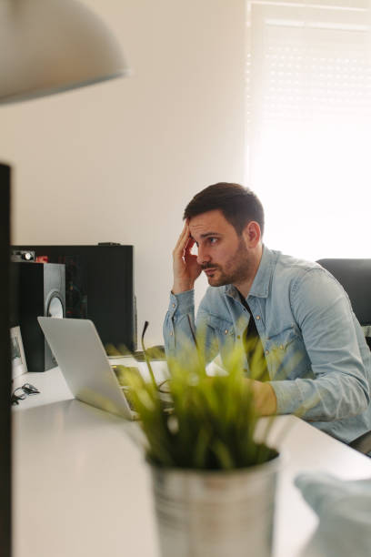 istock Male executive working over laptop and graphic tablet at his desk 939869454