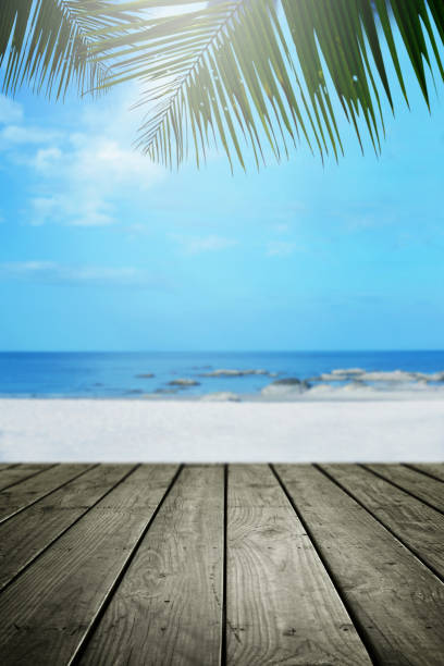 istock Beach background with palm tree and empty wooden. 939872966