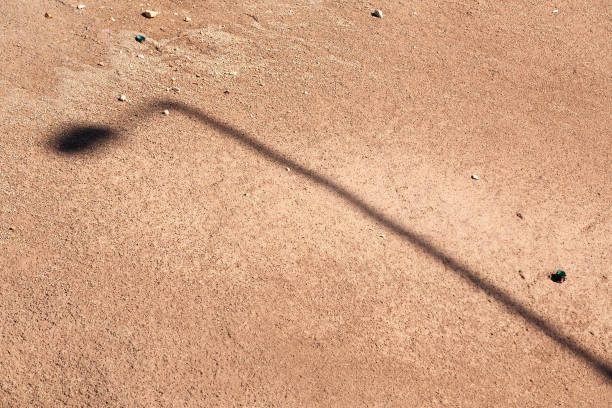 istock Shadow of a street lamp on a sand 939876672