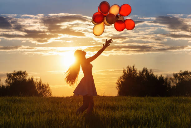 istock girl with balloons at sunset 939886872