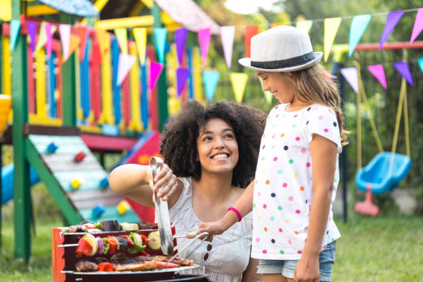 istock Mother and daughter preparing tasty barbecue on back yard 939890966