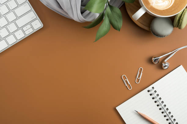 istock Styled stock photography brown office desk table with blank notebook, computer, supplies and coffee cup. Top view with copy space. Flat lay. 939898352