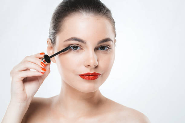 istock Mascara makeup woman face with red lips and manicure nails isolated on white 939901320