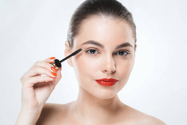 istock Mascara makeup woman face with red lips and manicure nails isolated on white 939901326