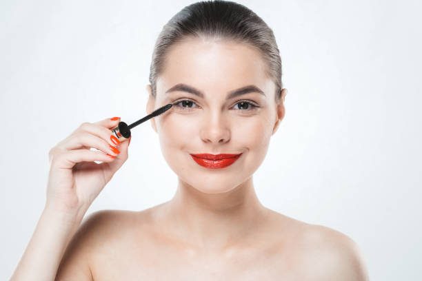 istock Mascara makeup woman face with red lips and manicure nails isolated on white 939901374