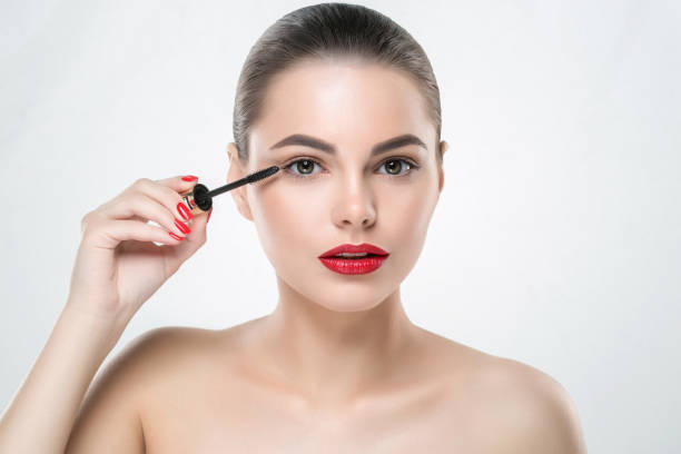 istock Mascara makeup woman face with red lips and manicure nails isolated on white 939901530