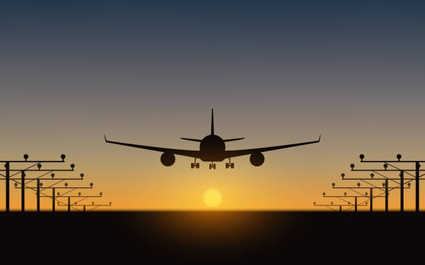 istock silhouette of Passenger airplane landing on runway and sunset sky background 939915322