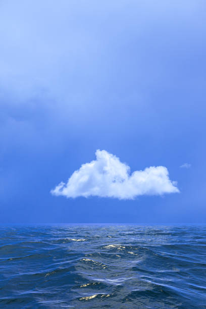 istock Background of sky with a single cloud reflected in water or ocea 939926706