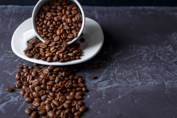 istock Cup coffee beans on textural dark table close up, copy space place for your text. 939929782