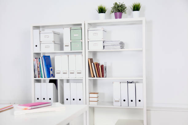 istock Modern office interior with tables, chairs and bookcases 939931572