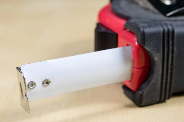 istock Measuring tools in a carpentry workshop. Steel measuring tape on a wooden table. Black background. 939934206