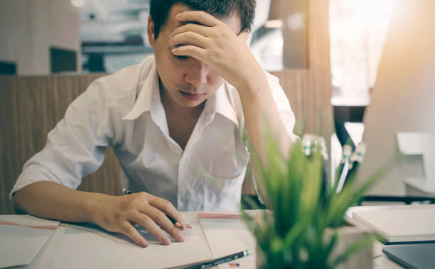 istock Stressed male designer sitting at desk in  office 939937338
