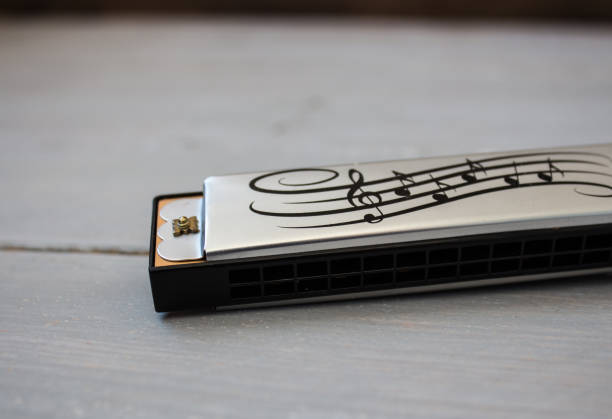 harmonica on wooden background a silver harmonica on a wooden background harmonica stock pictures, royalty-free photos & images