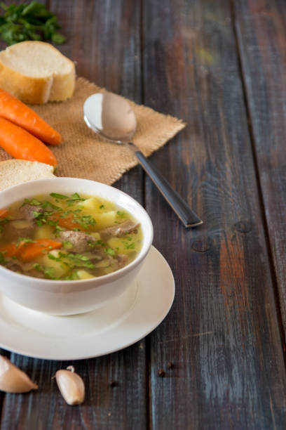 istock Soup with meat, potatoes and carrot. Beef soup in a white bowl, copy space 939942934