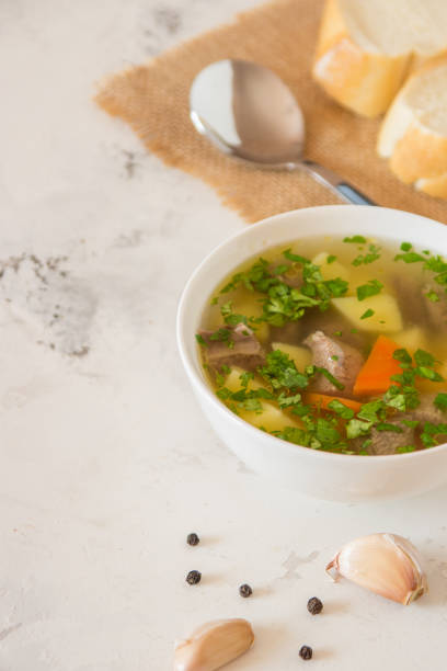 istock Soup with meat, potatoes and carrot. Beef soup in a white bowl, copy space 939942958