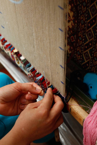 Close up of old woman weaving colorful pattern on loom Traditional woven and carpets carpet factory stock pictures, royalty-free photos & images