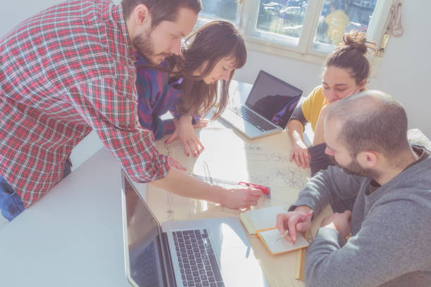 istock Group of young architects in the sunny office. 939946252