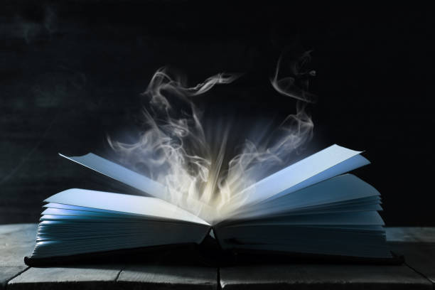 istock image of open antique book over wooden table. 939947798