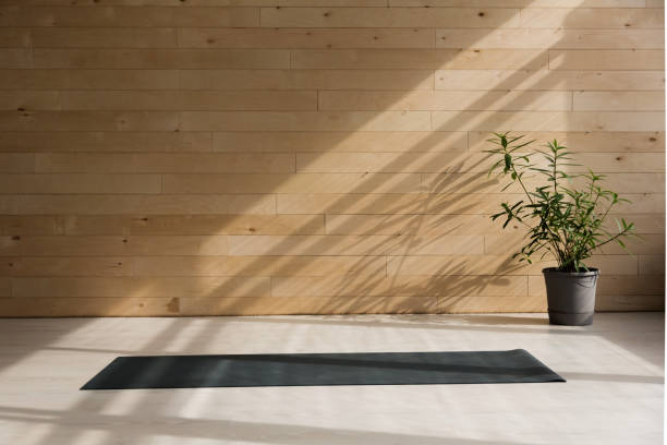istock Yoga mat on the floor with shadows from window 939963030