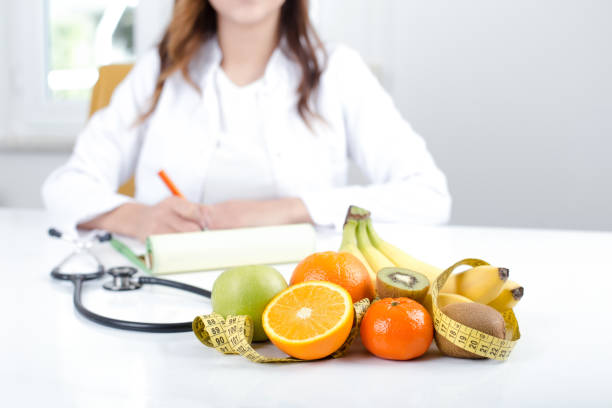 médecin nutritionniste avec fruits et légumes - fruits medecine photos et images de collection