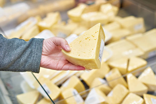 istock Hand buyer with piece of cheese in store 939974846