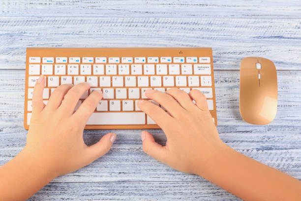 istock top view on female hands near wireless gold keyboard and mouse 939978732