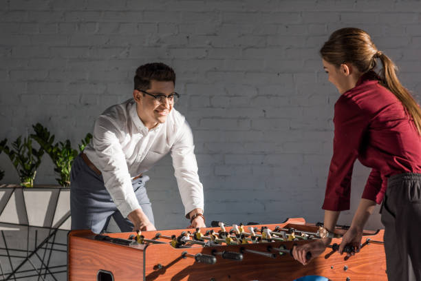 istock happy business partners playing table football at modern office 939978964